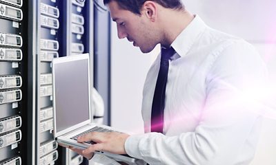 Man in data center working on a laptop
