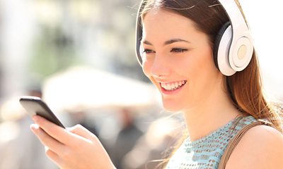 Woman wearing headphones using phone