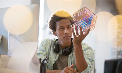 man holding and looking at abstract 3d virtual cube