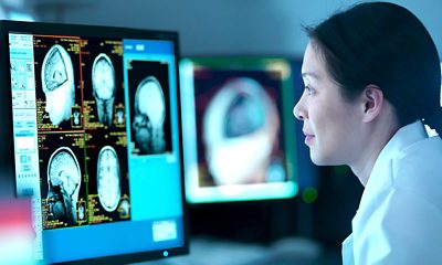 Woman looking at computer with artificial intelligence brain images