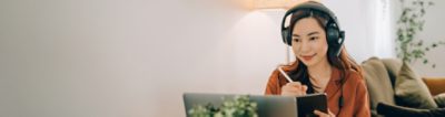 Smiling lady with headphones looking at computer