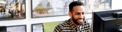 Smiling man looking at computer