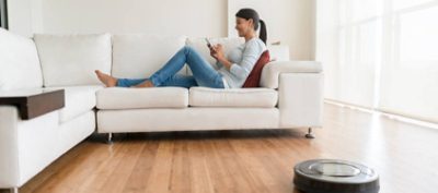 Woman using smart home technologies and relaxing in the sofa 