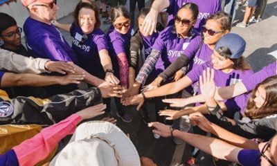 Group of people putting their hands in the middle of a circle